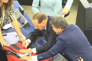 Berlusconi autografa una maglietta del Milan (ANSA)