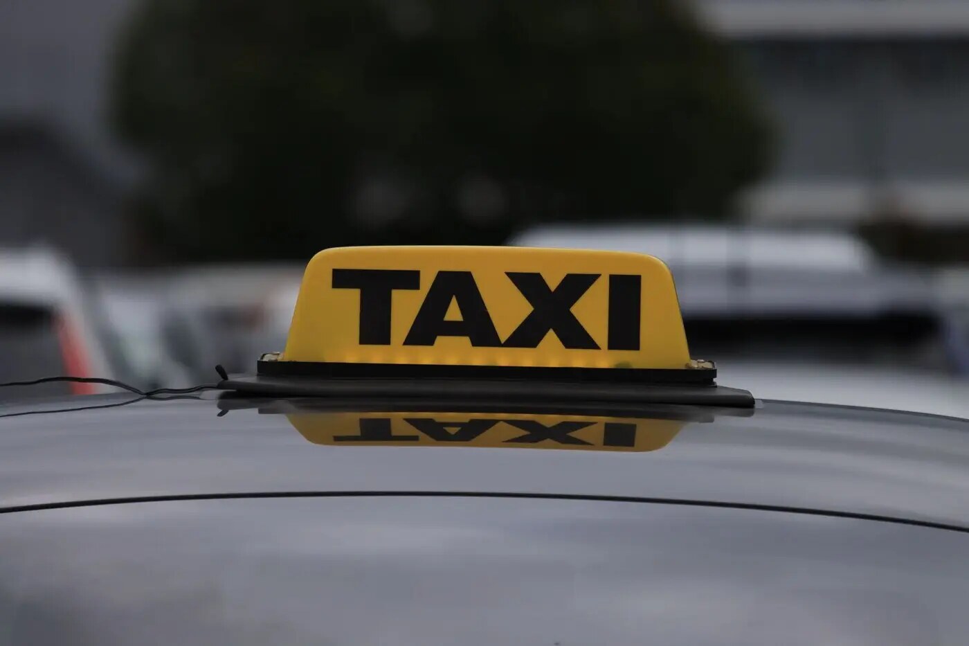 示意图:出租车车顶的黄色 TAXI 灯箱,背景为虚化的车辆与树木(图:Efrem Efre / Pexels,图库照片,与本次罢工无直接关联)